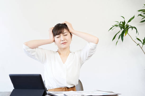 Asian business woman worried about work Asian business woman worried about work head in hands stock pictures, royalty-free photos & images