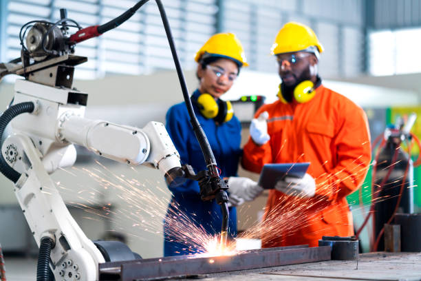 cooperación de ingenieros hombre y mujer técnico de mantenimiento control de relé robot sistema de soldadura con tablet laptop para controlar la calidad de funcionamiento proceso trabajo industria pesada 4.0 fábrica de fabricación - industry asian ethnicity asia manager fotografías e imágenes de stock