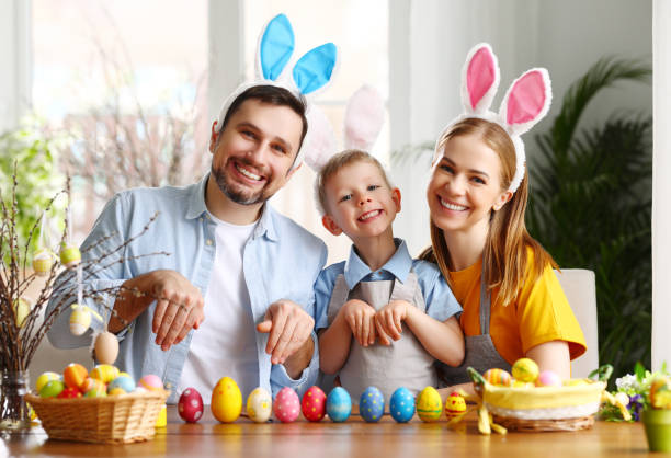 istock Family in bunny ears and with painted Easter eggs at home 1308247667