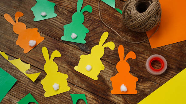 istock Easter bunnies made of paper on a wooden background. Create a decor for easter 1308249023