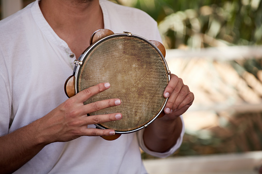 Close-up of a street musician playing Tambourine