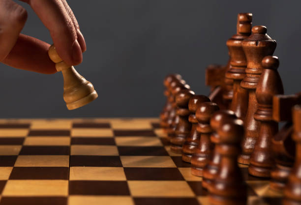istock One white pawn struggle against group of chess figures, concept 1308250871