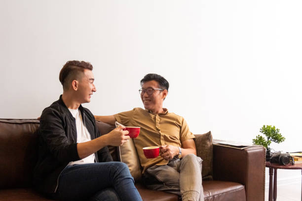 Asian Man Enjoy Coffee Together In The Living Room
