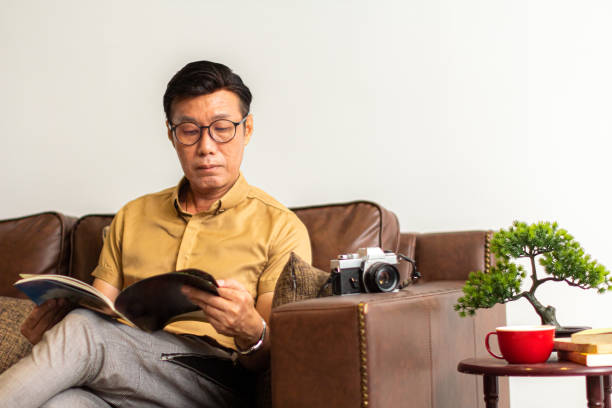 Asian Man Enjoy Reading In Living Hall
