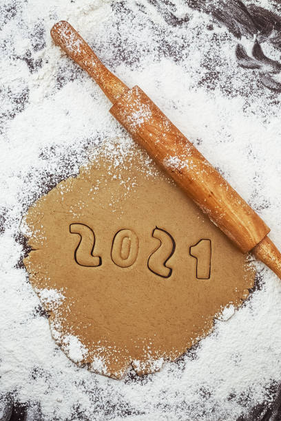 istock 2021 numbers cut from rolled raw cookie dough on flour brown table and rolling pin 1308258432