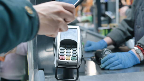 istock Man hand holds smartphone and pays bringing to terminal 1308258698