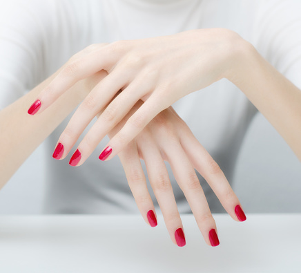 Beautiful caucasian female hands with red fingernails.