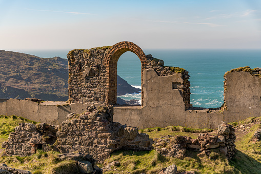 A ruined arch with a view through to the Atlantic ocean