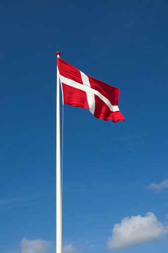 The denmark or danish flag with blue sky on background