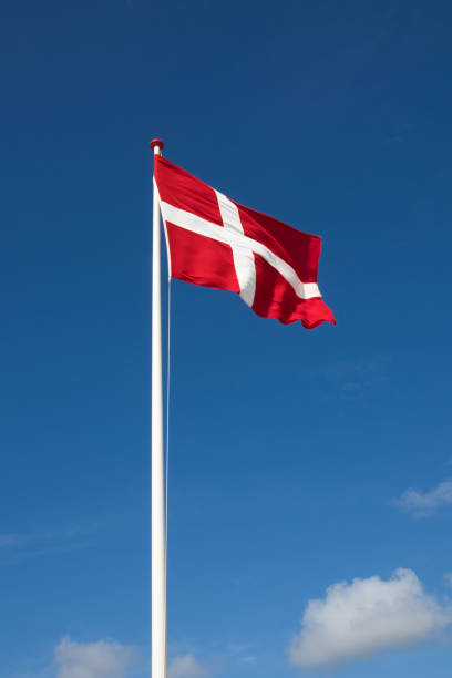 the danish flag with blue sky on background - danish flag imagens e fotografias de stock