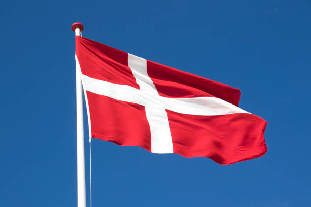 istock The danish flag with blue sky on background 1308262880