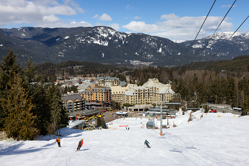 Whistler, British Columbia, Canada - March 10, 2021: Chalets and Vacation Homes in a Village at a Famous Ski Resort with Mountains Landscape in Background