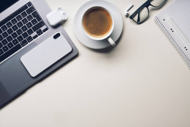 istock Workplace in office with white desk. Top view from above of keyboard with notebook and coffee. Space for modern creative work of designer. Flat lay with blank copy space. Business and finance concept. 1308265574