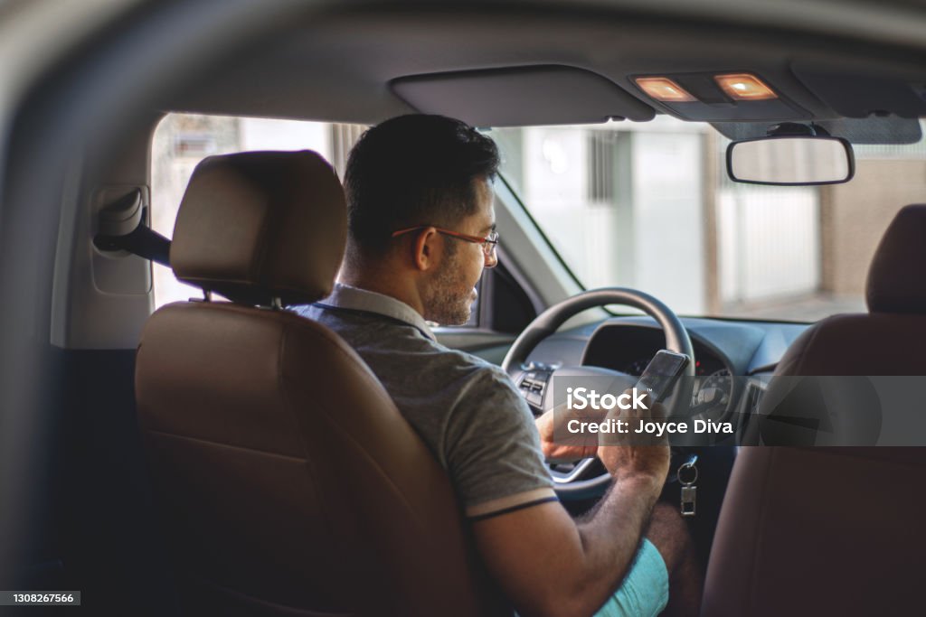 Driver inside the car Driver inside the car connectivity with smartphone Taxi Driver Stock Photo