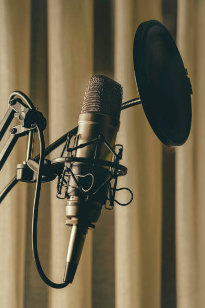 istock Studio condenser microphone with anti-pop filter and anti-shake mount with colored backlight blue . Side view 1308270815