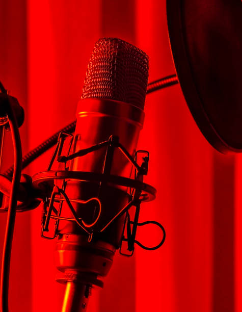 istock Macro, Studio condenser microphone with anti-pop filter and anti-shake mount with colored backlight blue . Side view 1308270819