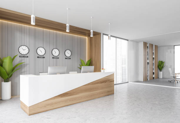 istock White reception room desk with computers and clocks on the wall 1308271595
