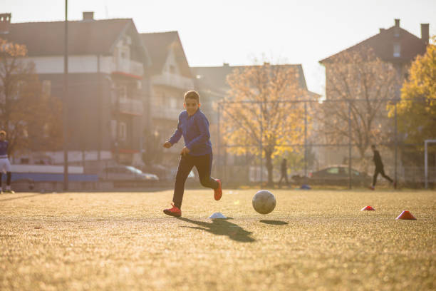 istock Happy young boy playing soccer 1308273370