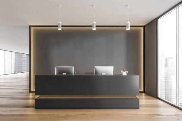 istock Black and wooden reception room desk with computers near window 1308274829