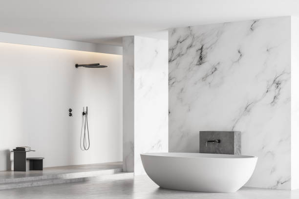 istock White bathtub and shower in light marble bathroom with window 1308274893