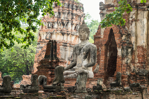 Ancient sand stone ruined Buddha statue at wat Mahathat temple, Ayutthaya, Thailand, UNESCO famous travel destination in southeast asia.