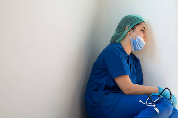 istock Sad nurse sitting on floor 1308277167