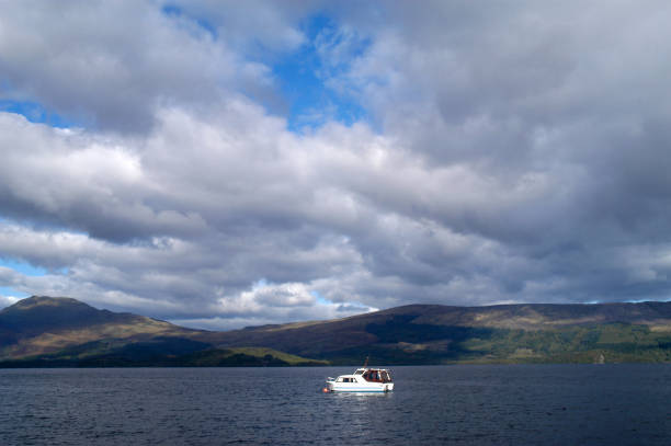 ベン・ローモンドとロッホのメイドを示すスコットランドのローモンド湖に停泊したボート - highlands region heather grass mountain range ストックフォトと画像
