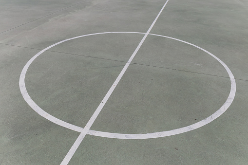 center of a playing field, white lines painted on the ground, circle crossed in the center by a line