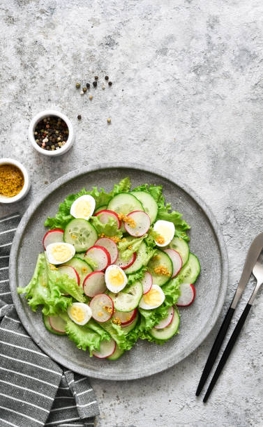 istock Spring salad with radish, cucumber, egg and salad leaves on a concrete plate. 1308281736