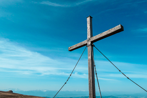 Sauofen - A wooden cross on top of Sauofen in Austrian Alps. Fall vibes. Mountain chains in the back. Panoramic view.