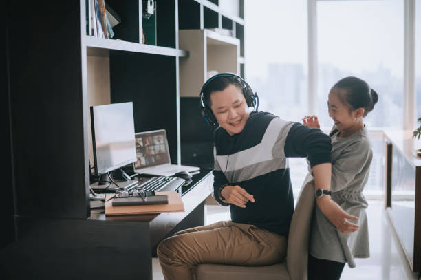 istock mischief asian chinese daughter distracting playing disturbing her father who working from home routine with headset videocall with his colleague coworking 1308286578