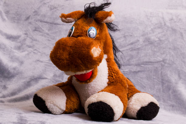 Soft plush toy horse on gray background