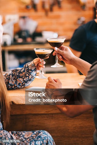 istock couple holding glass with espresso martini cocktail, decorated with coffee bean. 1308287596