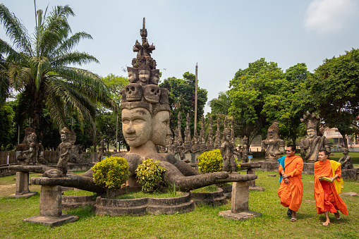 Vientiane, Laos - April 6, 2017: Novice Buddhist monks at Wat Xieng Khuan aka Buddha Park, a sculpture park by the Mekong River near Vientiane, Laos.