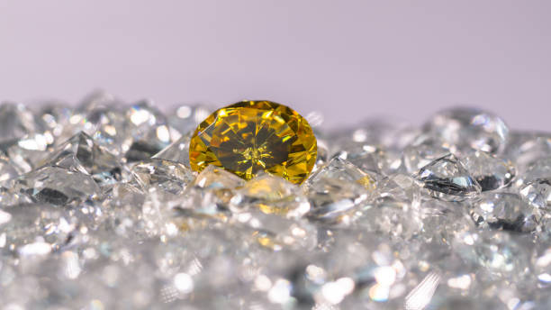 istock Yellow sapphire diamond on a pile of white diamonds. 1308290669