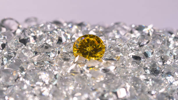 istock Yellow sapphire diamond on a pile of white diamonds. 1308290690