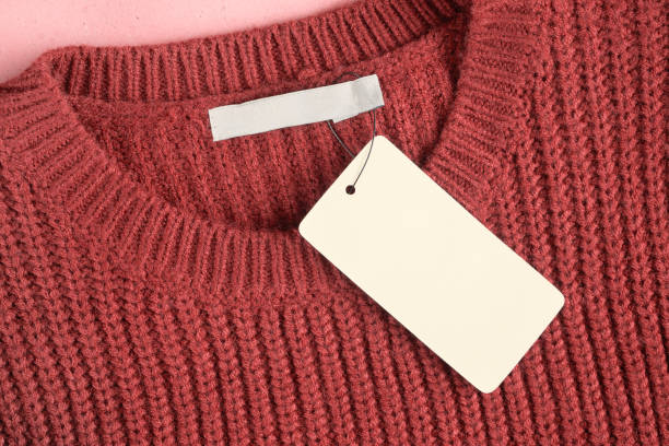 Mockup of a label and an inner label on the neck of a pretty red wool sweater. Blank space to place a logo, text or image stock photo