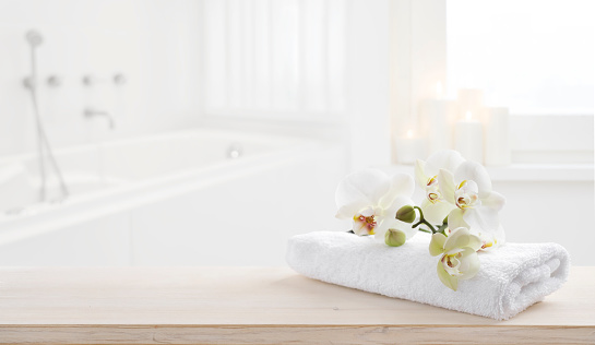 Towel and orchid flowers on wooden table with copy space