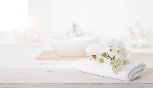 istock White folded spa towel and orchid flowers on wooden table 1308291904