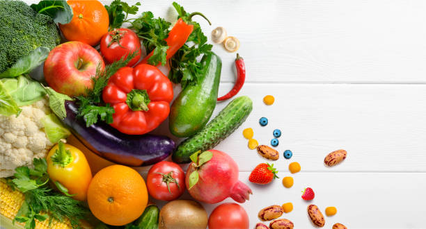 オーガニックの健康的な食品の背景。白い木製のテーブルの背景に食べ物の写真異なる果物や野菜。トップビュー - 八百屋 ストックフォトと画像
