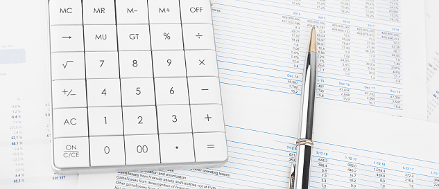 Calculator on financial statement and balance sheeet on desk of auditor. Concept of accounting and audit business.