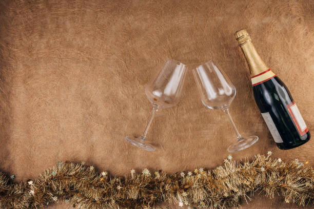 Wine glasses  and champagne bottle on brown background. Flat lay concept.