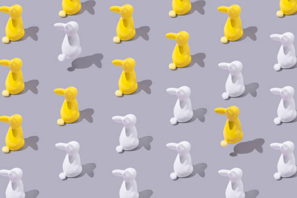 istock Creative pattern with yellow and white plastic bunny on grey background. Minimalist concept. Isometric layout. 1308293687