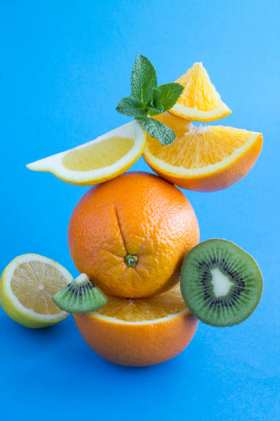 istock Oranges and kiwi stacked pyramid on the blue background 1308295298