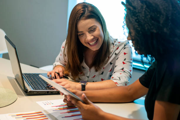 istock Two young women talking in an office. 1308296712
