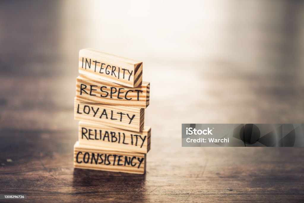 Integrity concept Businessman staking wood blocks with words hand written on them.  He is explaining the integrity values. Morality Stock Photo
