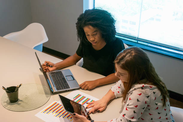 istock Two young women talking in an office. 1308297313