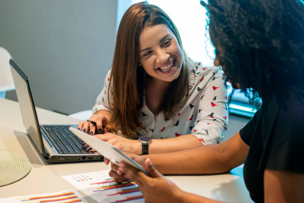 istock Two young women talking in an office. 1308298093