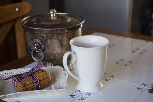 Table with tea cup, cookies and tangerines, close-up