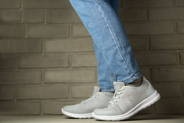 istock Female leg in jeans and sneakers, copy space template. 1308300543
